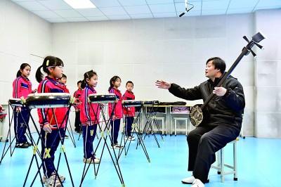 圖為12月30日，在惠民縣胡集鎮(zhèn)第一小學(xué)，老師指導(dǎo)學(xué)生學(xué)習(xí)西河大鼓。新華社記者 郭緒雷攝