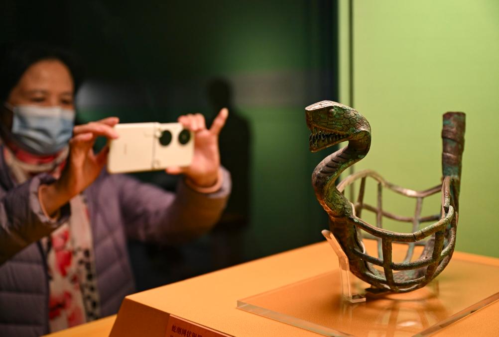1月14日，觀眾在上海博物館蛇年迎春展拍攝展品蛇綱網(wǎng)狀銅器。新華社發(fā)（陳浩明攝）