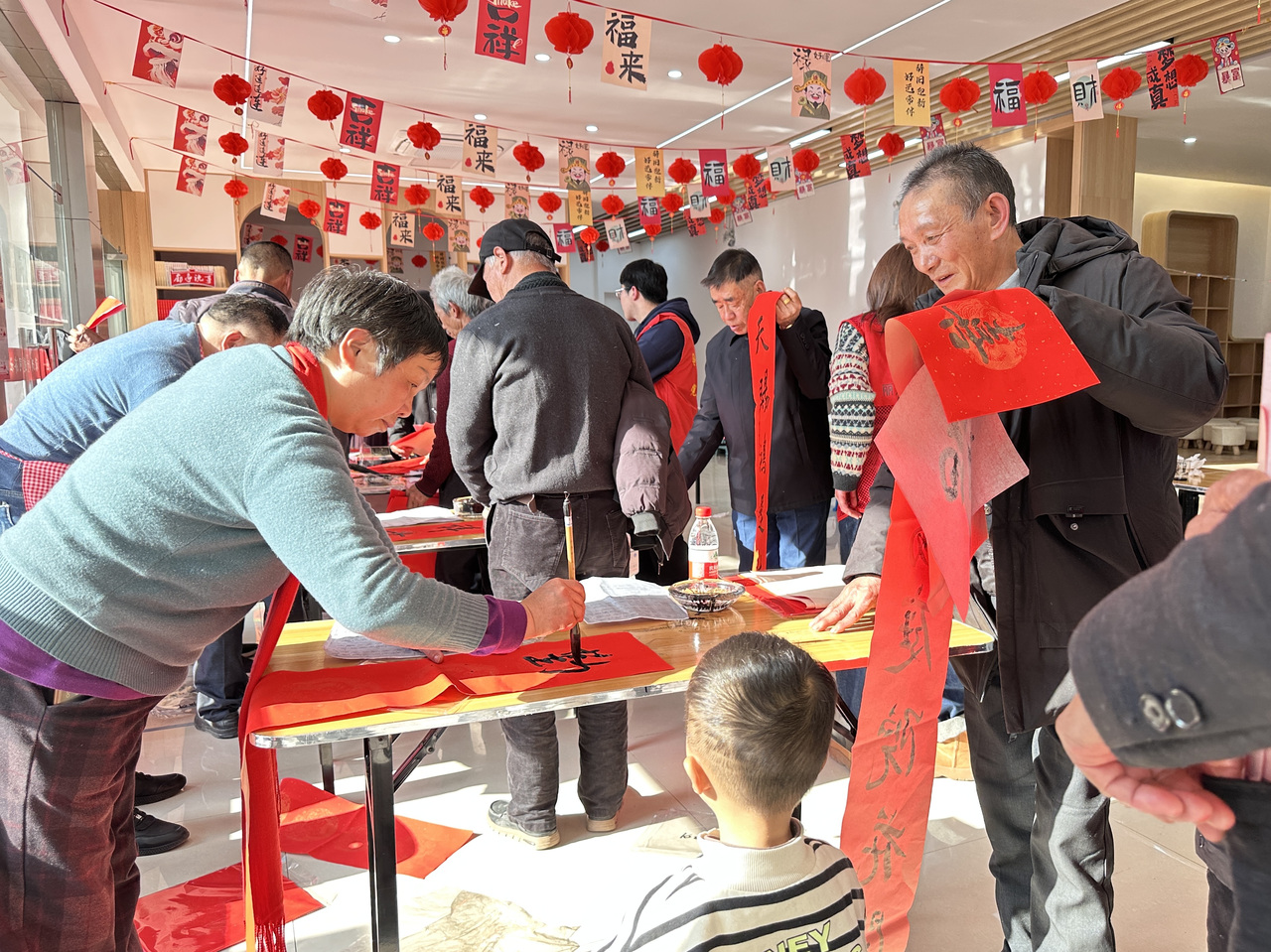 今年春節(jié)前夕，慶元縣濛洲街道同濟新村，一場送春聯(lián)活動熱鬧舉行。慶元縣融媒體中心 供圖
