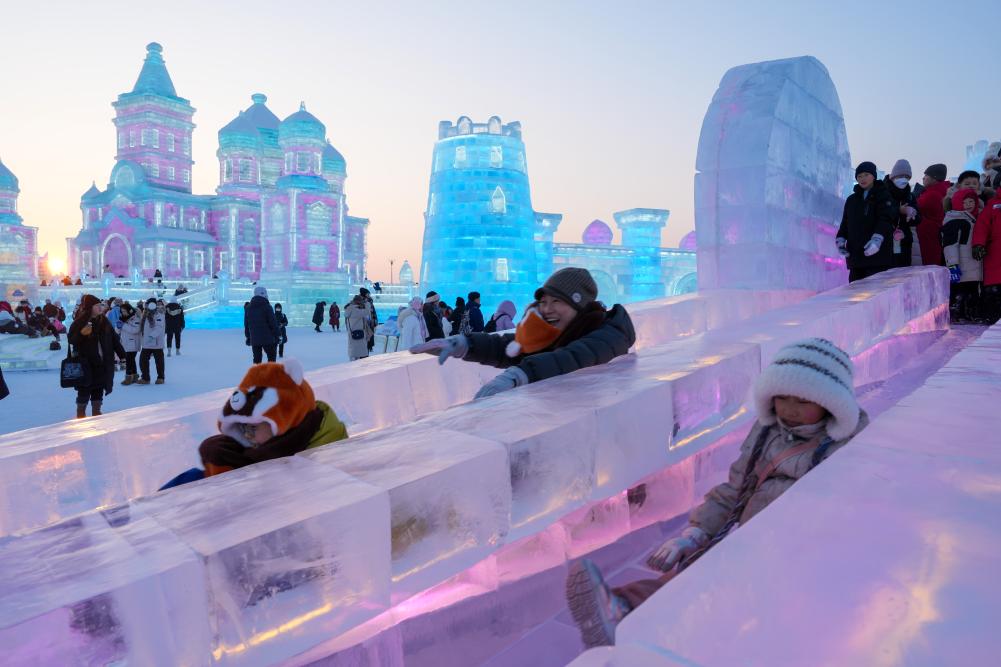 游客在哈爾濱冰雪大世界園區(qū)內(nèi)體驗(yàn)冰滑梯。新華社發(fā)