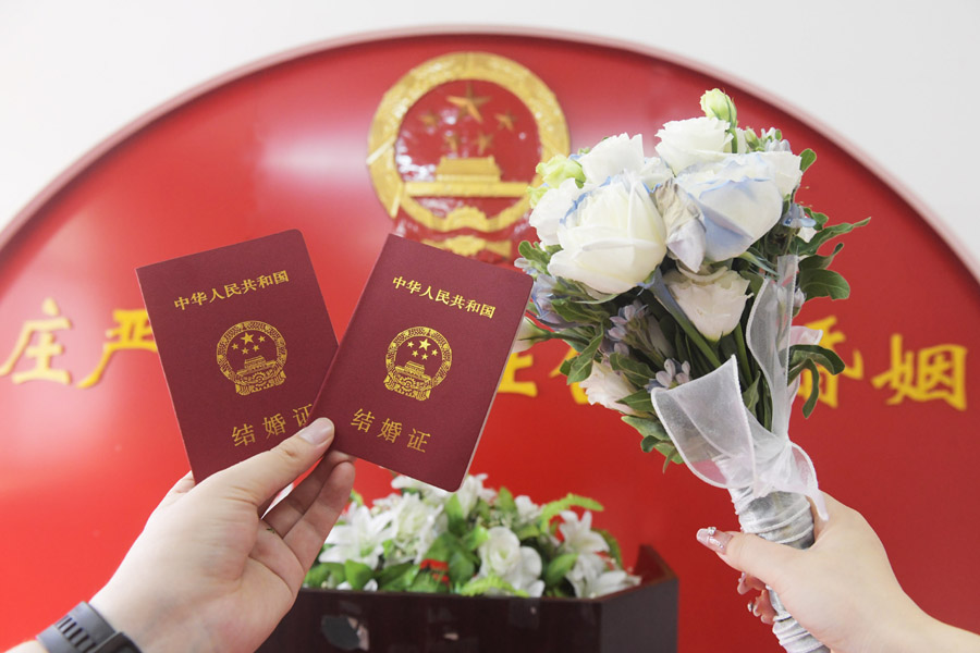 2024年8月10日，一對新人在河北石家莊新樂市民政局婚姻登記處領(lǐng)取結(jié)婚證后拍照留念。新華社發(fā)（賈敏杰攝）