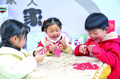 圖為孩子們?cè)诶蠋熤笇?dǎo)下制作蛇年主題剪紙。 新華社記者 徐昱攝