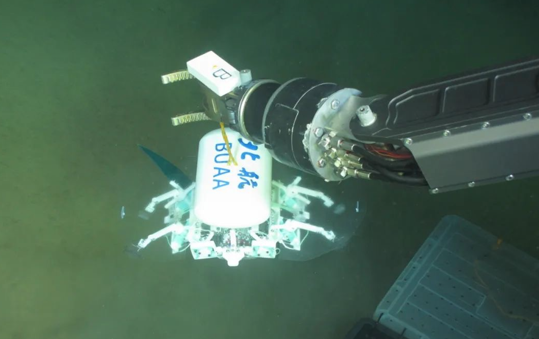 科研人員利用機械臂將北航深海小型機器人投于馬里亞納海溝。校方供圖
