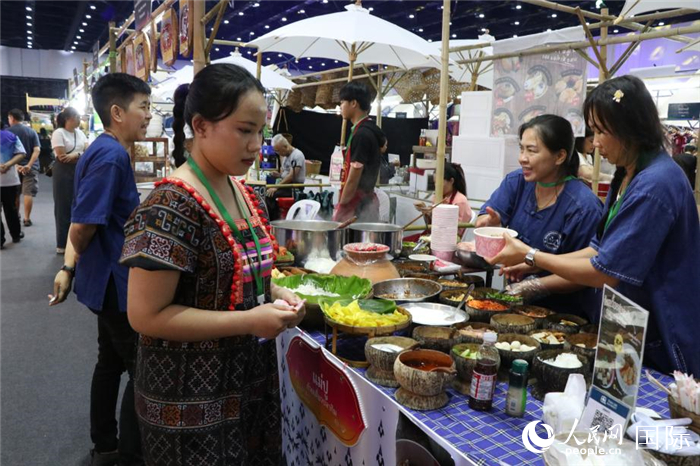 游客在攤位前購(gòu)買(mǎi)特色美食。朱瀟逸攝