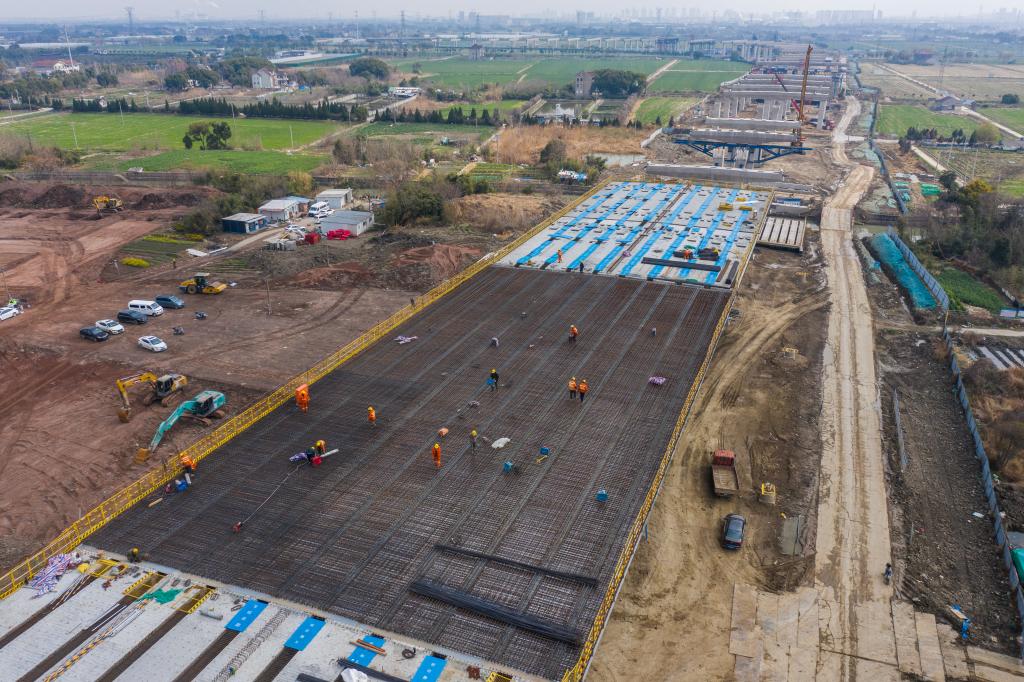 3月7日，在524國道秀洲王江涇至新塍公路工程TJ02標(biāo)段，作業(yè)人員正在進行60米鋼混組合梁現(xiàn)澆橋面板鋼筋焊接及綁扎作業(yè)（無人機照片）。新華社記者 徐昱 攝