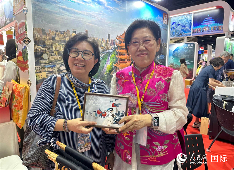 中國“大冶刺繡”傳承人劉小紅（右）參加泰國國際旅游展，向觀眾介紹中國非遺刺繡針法。人民網(wǎng)記者 簡承淵攝