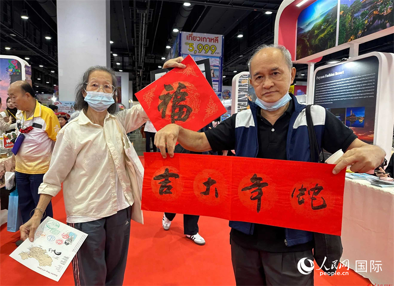 2025蛇年春節(jié)，泰國市民展示他們領(lǐng)到的華人手寫春聯(lián)。人民網(wǎng)記者 簡承淵攝