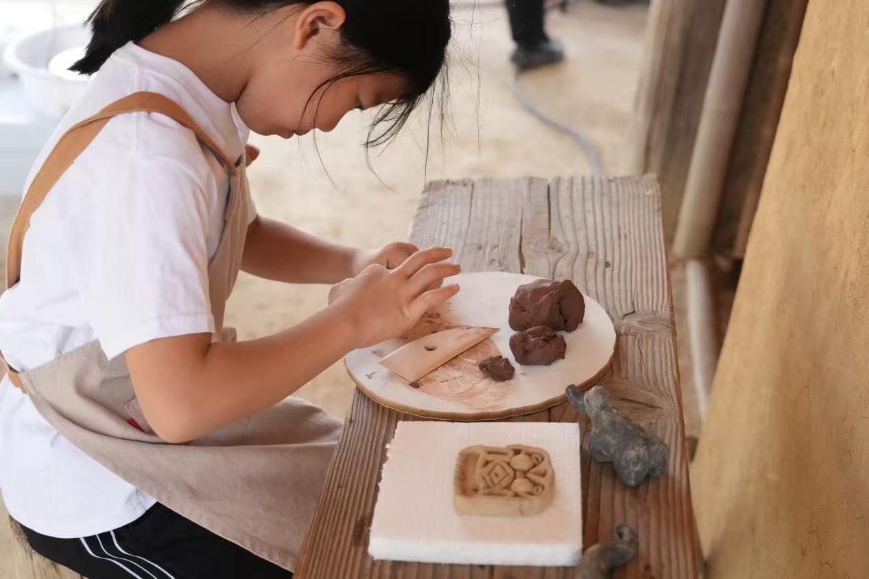游客制作良渚特色陶藝品。良渚博物院供圖